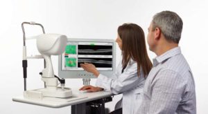 Two eye doctors assess a patient's images of their eyes for eye disease