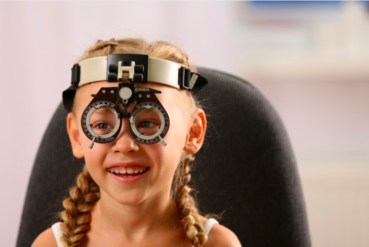 A little girl laughs at her eye exam