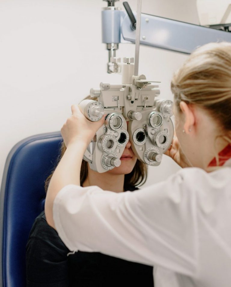An optometrist examines a young woman's eyes