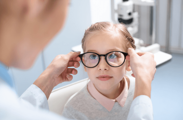 A young girl tries on myopia control glasses