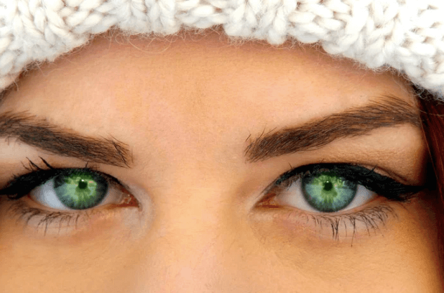 A woman wears green coloured weekly contacts